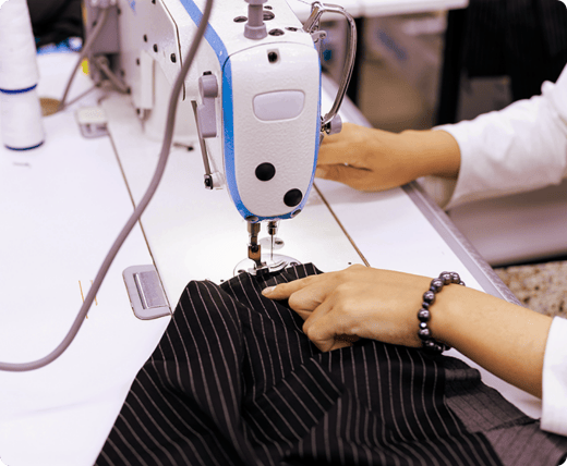 a_person_is_using_a_sewing_machine_on_black_pinstripe_fabric